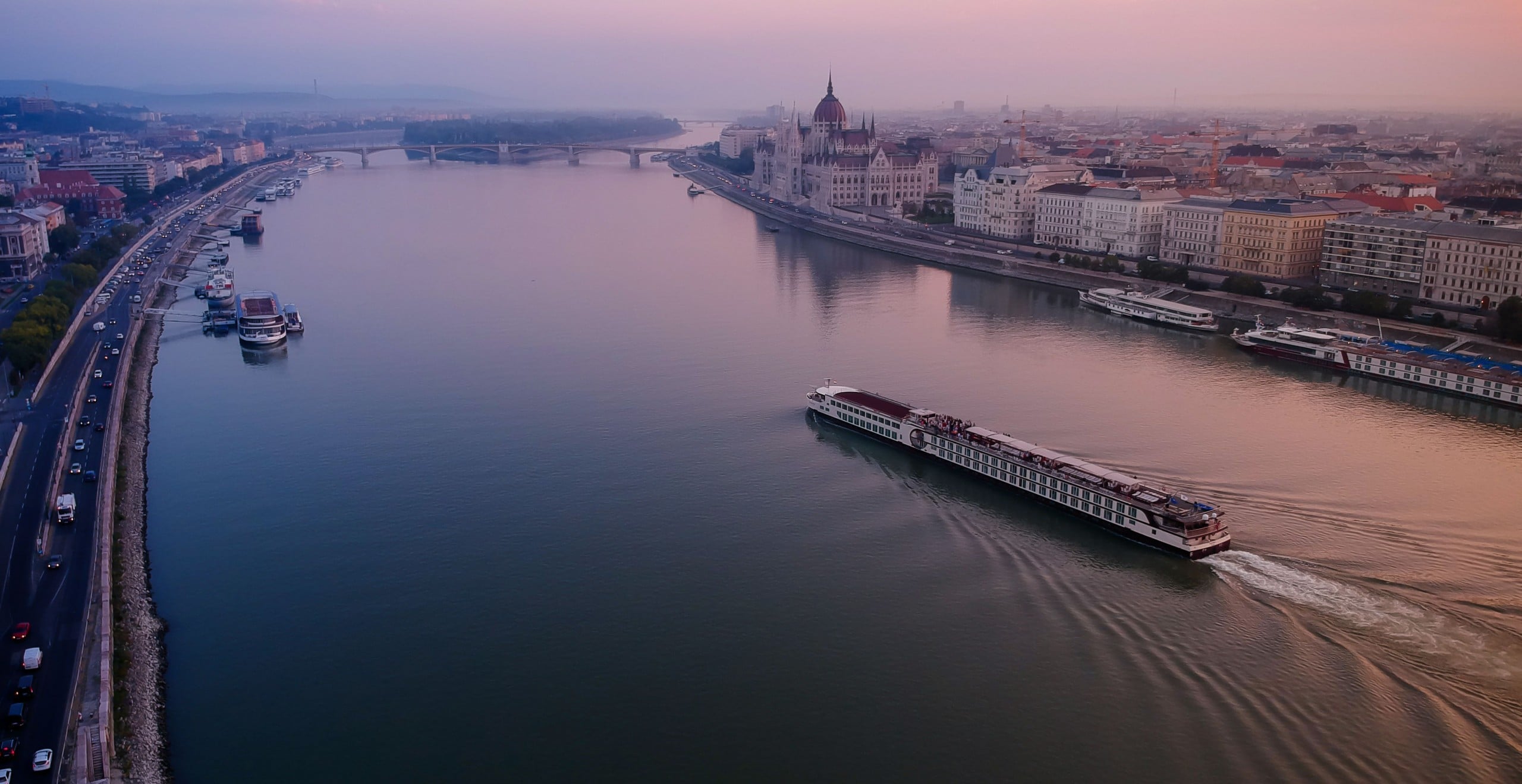 A river cruise is about to go past the Hungarian Parliament Building in an early morning. Image: Getty